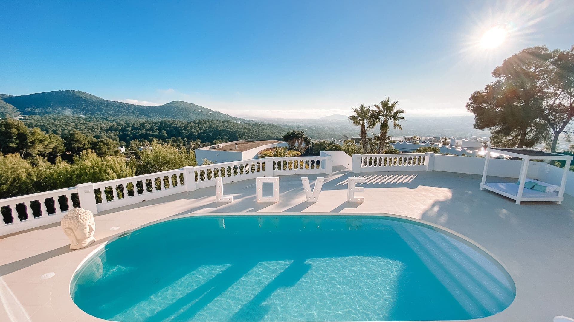 Pool of a white villa overlooking the hills of Ibiza